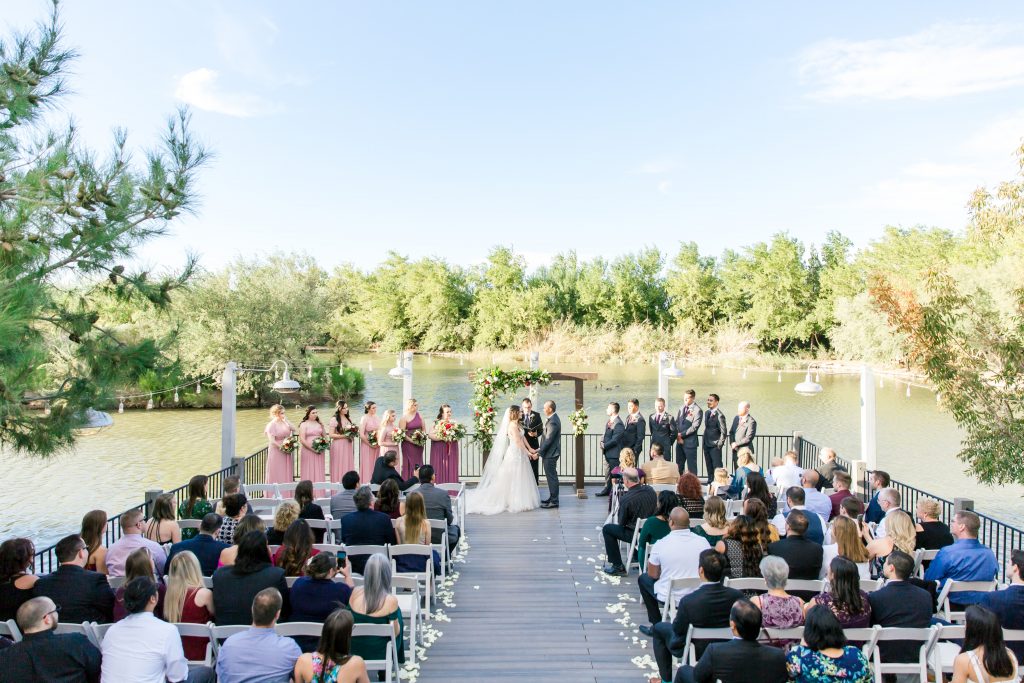 Wedding on the Windmill Winery dock with decorated arch and 13 attendants