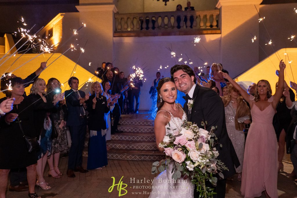 Couple with bouquet at sparkler reception exit